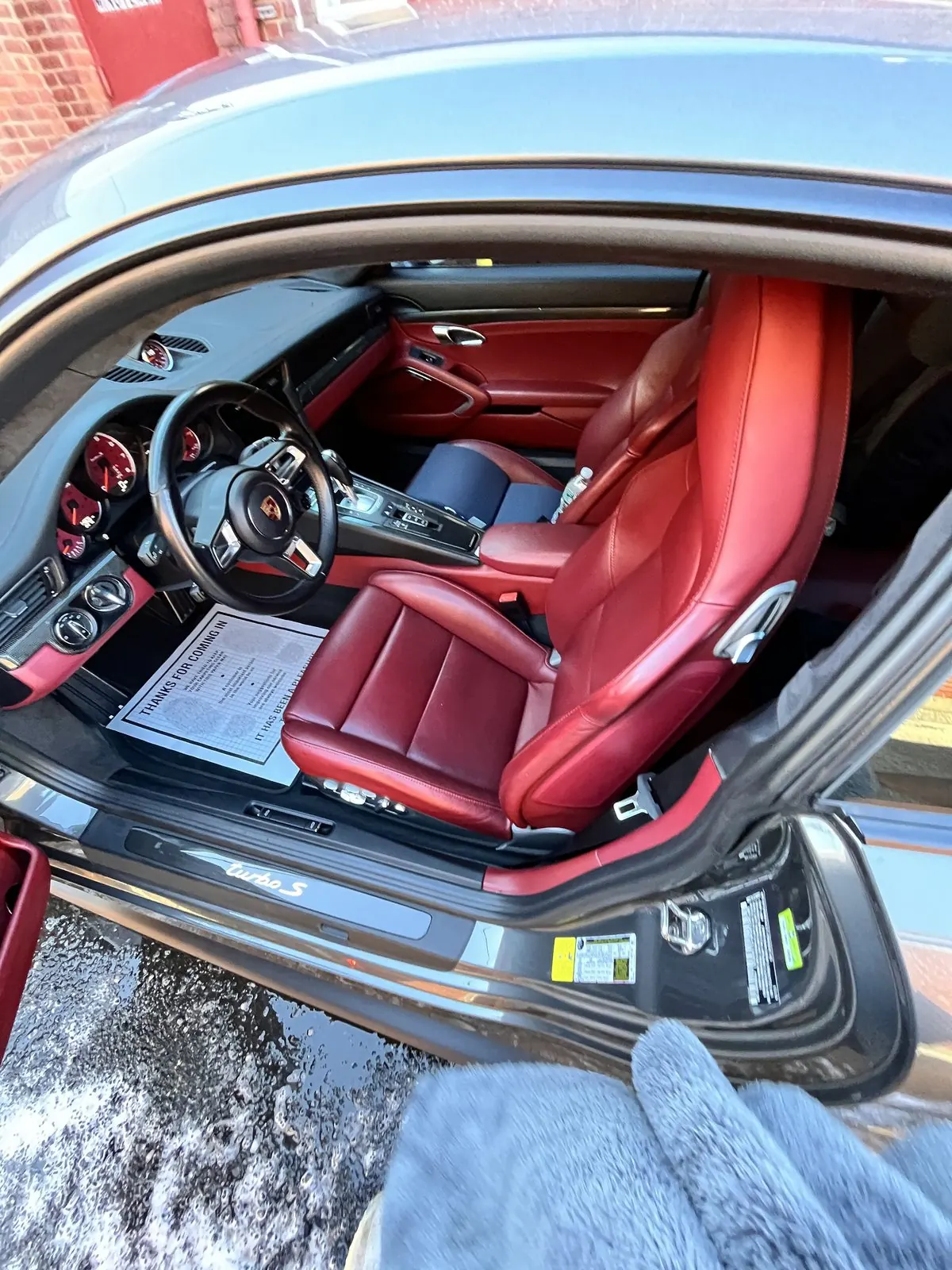The red leather interior of a Porsche 911 Turbo S after detailing
