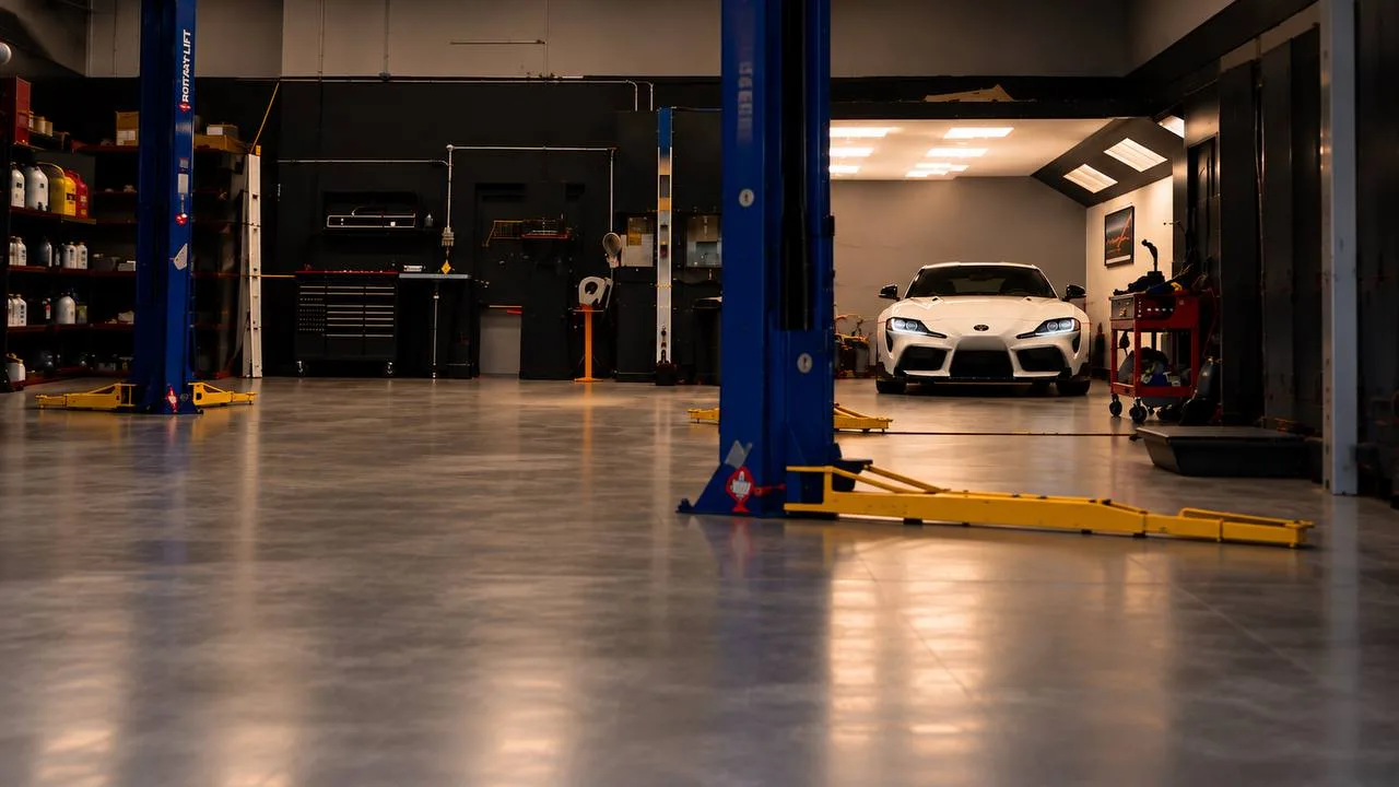 The shop floor at Custom Auto Care with two Rotary lifts and shelves of product